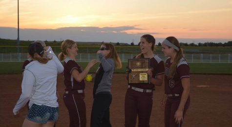 Seniors Shannon Schumacher, Kylie Brown and Tessa Stickel share congratulatory hugs with former coach and government instructor, Abby Maska. 
