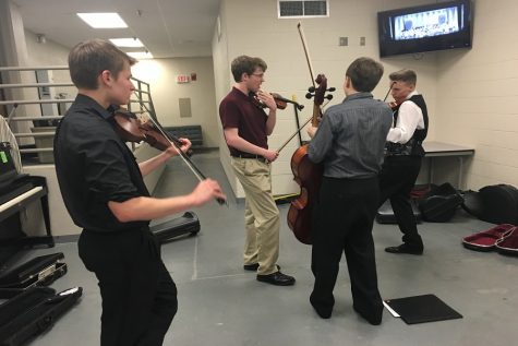 Junior Eric Rorstrom, seniors Ben Sadler and Tanner Moore, and sophomore Dawson Rooney rehearse downstairs in Beach Schmidt before performing. 