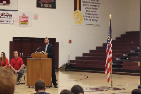 Katle speaks at the podium during the assembly.