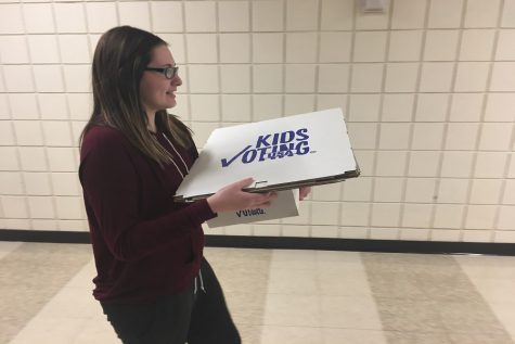 Senior Jordyn Dake carries ballots from her polling location into the cafeteria. 