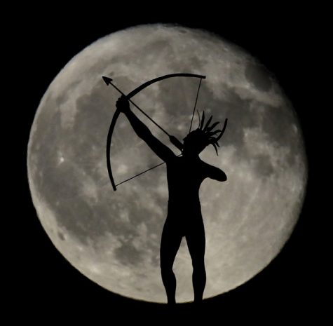 A waning full moon rises behind a statue of a Kansa Indian on top of the Kansas Statehouse Saturday, Sept. 17, 2016, in Topeka, Kan. (AP Photo/Charlie Riedel)