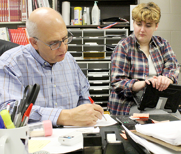 Journalism instructor Bill Gasper helps newspaper student Elizabeth Lee with story corrections.