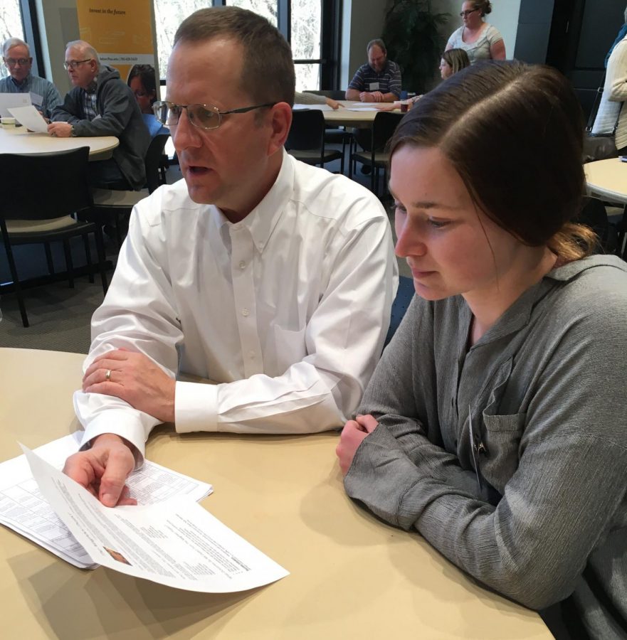 Senior+Lisa+Schoenberger+and+Principal+Martin+Straub+look+over+the+handout+for+the+Neighborhood+Project.+The+project+was+put+together+by+a+committee+with+the+intent+to+bring+together+members+of+our+community.